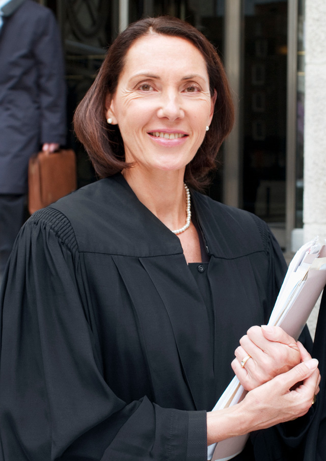 Lawyer looking at the camera and holding documents. 